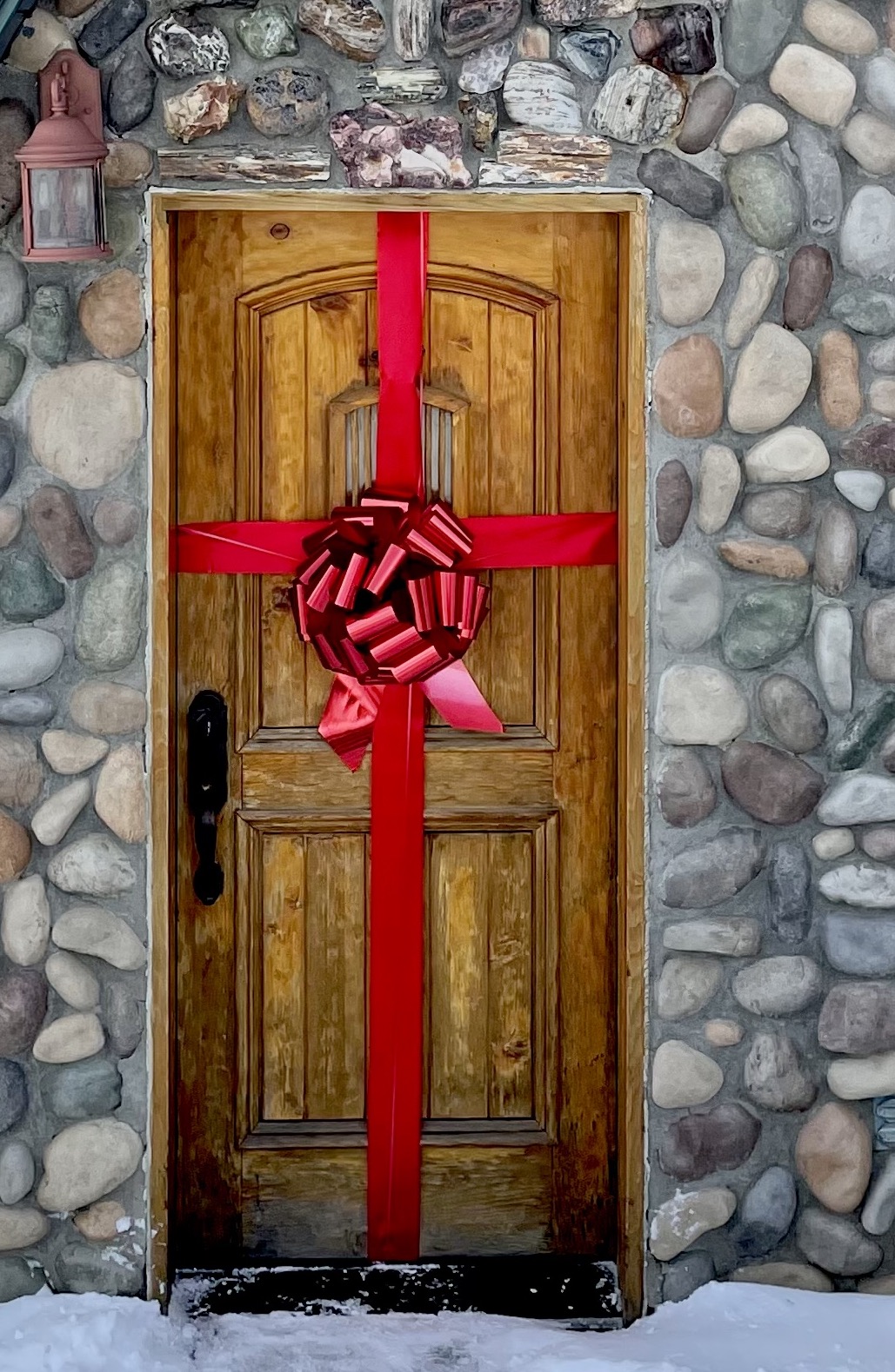 A bright red front door decorated with a large bow, symbolizing a warm welcome and celebration of moving into a new home. Perfect visual for new homeowners, real estate success, and move-in day excitement.