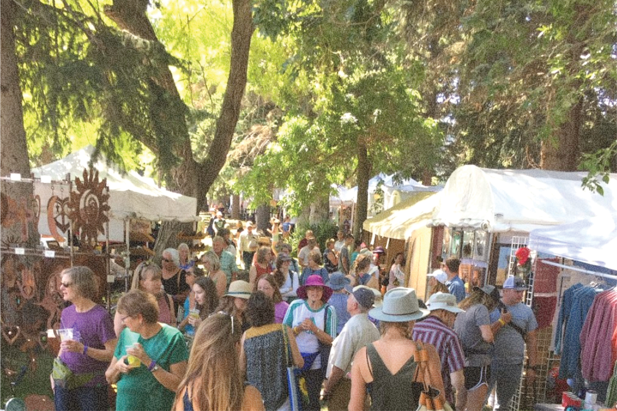 Vibrant artist booths and families shopping local art at the Bozeman Sweet Pea Festival